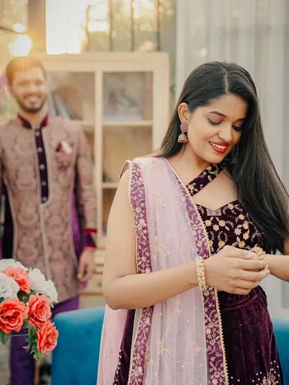A beautiful, soft-focus shot that captures a quiet moment. The intricate details of the lehenga and the matching sherwani are highlighted by the natural light.