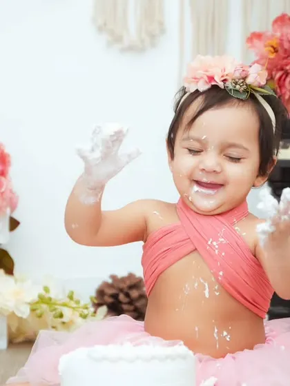 A moment of pure delight! Her eyes are closed in happiness as she enjoys her first birthday cake.