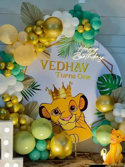 A roaring celebration for Vedhav's first birthday with this adorable Simba theme. The setup featured a crowned Simba on the backdrop, framed by a green, gold, and white balloon arch, a light-up number '1', and a small Simba statue for the perfect jungle vibe.
