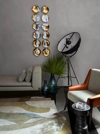 A serene grey living space in the Baid Residence, featuring a minimalist wall piece from Foscarini and a chic light from Pallucco. The space is a study in understated elegance and sophisticated curation.