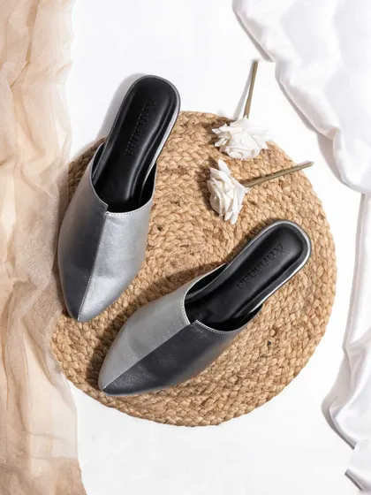 A rustic and chic flatlay for a pair of metallic mules. The use of a jute mat and soft, natural fabrics creates an earthy and stylish vibe, perfect for a brand with a bohemian aesthetic.