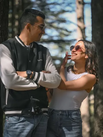 A playful, candid moment between a couple in a sun-dappled forest. This is the kind of relaxed, happy interaction I love to capture.