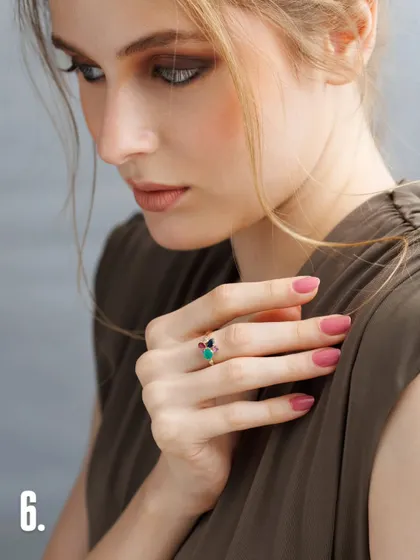 This shot demonstrates how a model's expression can change the mood of a piece. The downward glance and soft hand position give this multi-gemstone ring a feeling of quiet contemplation and elegance.
