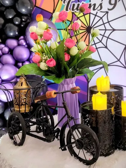 A close-up of the decorative details, including a miniature tricycle and faux candles.