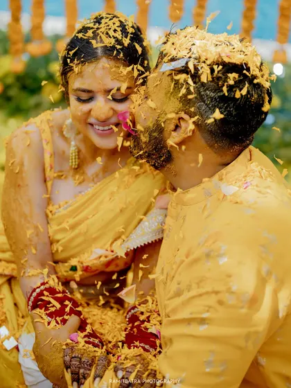 Covered in haldi and marigold petals, the couple shares a sweet, messy kiss.