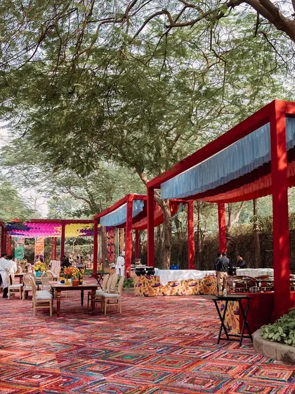 A view of the outdoor venue, showing the red-framed structures and the surrounding trees. The design integrates beautifully with the natural landscape.