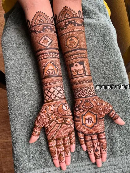 A subtle yet meaningful way to include your partner. This design features the initials "MR" elegantly placed on the palm, surrounded by traditional motifs like elephants and temple bells.