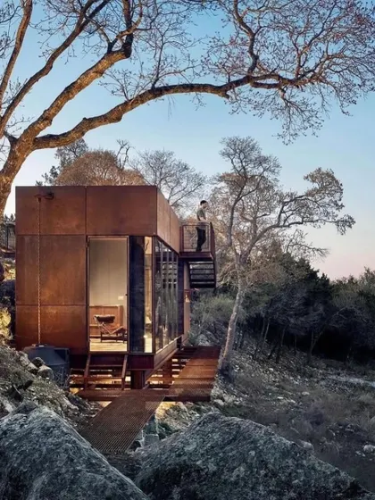 Our designs often incorporate sustainable features, like the rainwater harvesting system seen here on this rustic modular home. We believe in building homes that are not only beautiful but also environmentally responsible.
