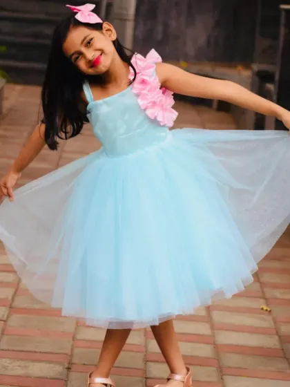 A happy client twirling in her sky blue birthday frock. The dress is made with layers of soft net, perfect for dancing and playing.