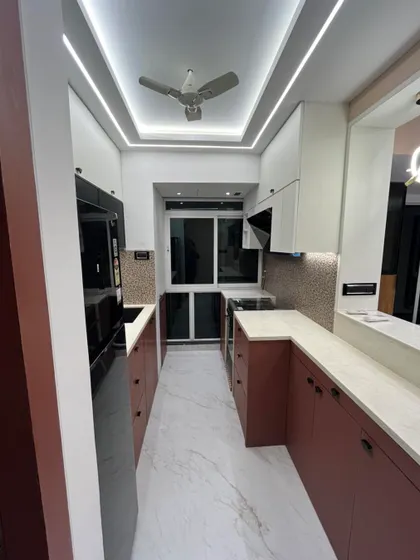 This shot highlights the layered lighting design in the kitchen, with ceiling lights for overall illumination and under-cabinet lights for task areas. Good lighting is essential for both function and ambiance.