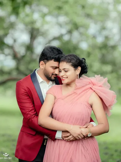 A close-up, romantic embrace in a beautiful green field. The focus is entirely on the couple's connection, with the soft, natural surroundings creating a peaceful mood.