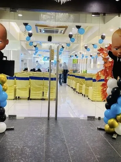 The Boss Baby theme is perfect for a little one who rules the house. This setup for Dhven's first birthday features character cutouts, a themed backdrop, and a professional blue, black, and gold color scheme.