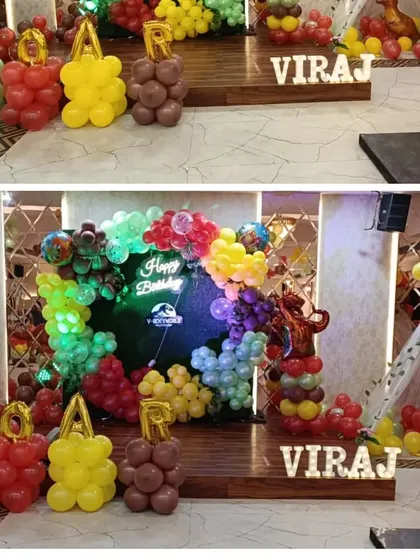 More details from the dinosaur-themed party, showing the custom balloon letters and the main backdrop with a neon sign.