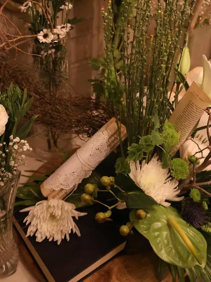 A detailed composition of white flowers, green foliage, and vintage paper elements. This showcases our skill in floral design and creating layered, visually interesting arrangements.