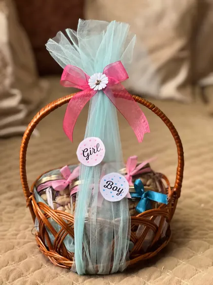 A beautifully wrapped wicker basket for a baby shower. I use delicate tulle and ribbons, adding "Girl" and "Boy" stickers to make it a perfect gift for a gender reveal event.