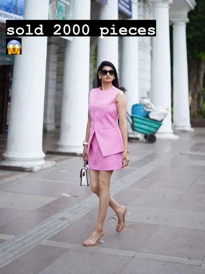 This is my best-selling two-piece set, featuring a sleeveless waistcoat-style top and a matching mini skirt. It's a modern, sharp look for any semi-formal occasion, shown here in a vibrant pink.