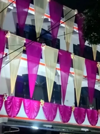 A house facade at night decorated with vertical drapes in off-white and pink, creating an elegant and festive look.
