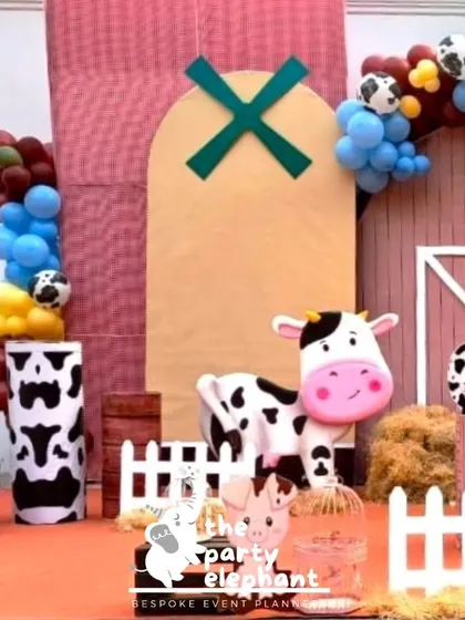 A closer view of the barnyard backdrop, showing the cute cow prop and cow-print details on the pillars. I use a mix of printed backdrops and 3D props to create a dynamic and engaging scene.