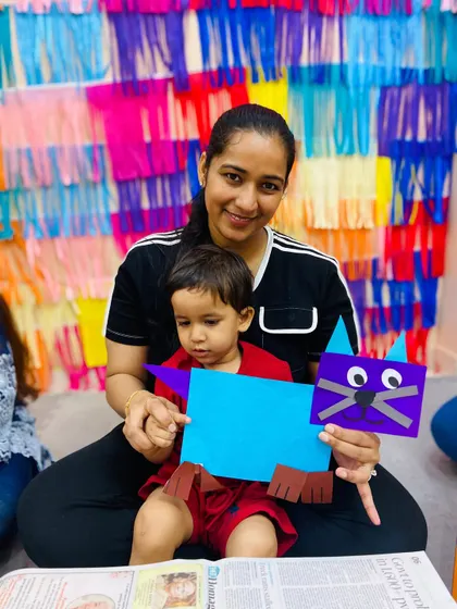 A mother and child at our Pitampura center display their colorful cat craft, made from simple paper shapes.