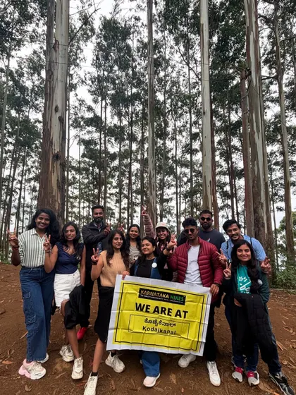 Our group with the banner in the tall, atmospheric pine forests of Kodaikanal.