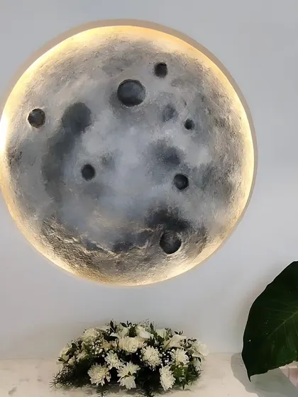 The finished moon mural installed above a console table, creating a serene and welcoming vignette. It's a perfect example of custom art for a specific nook.