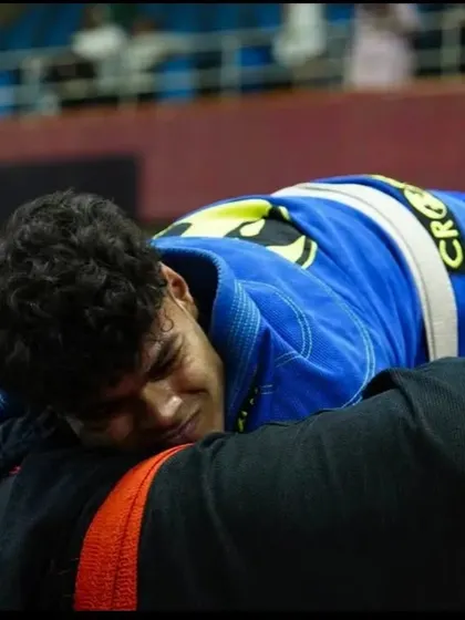 The face of exhaustion and determination. This is the reality of a tough Jiu-Jitsu match, pushing through pain to secure a dominant position.
