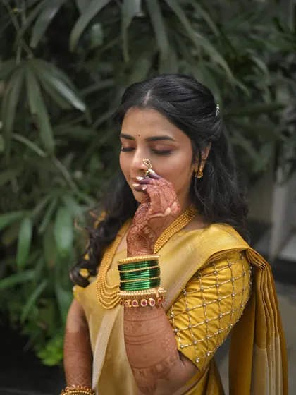 A close-up of the bride's hand with the nath, showcasing the soft and subtle makeup.