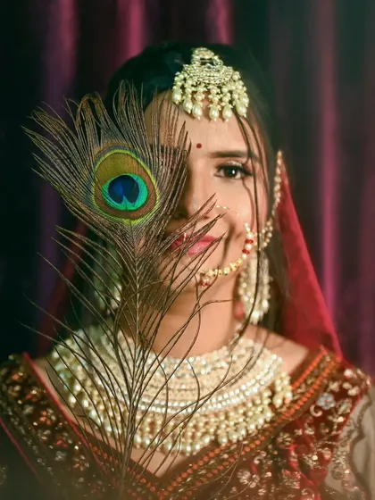 A creative bridal portrait with a peacock feather, adding a touch of traditional artistry.