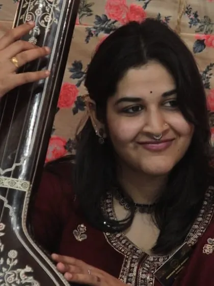 A student providing tanpura support, an essential part of any classical performance.