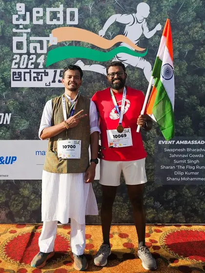 A participant poses with an event ambassador in front of the Freedom Run backdrop.