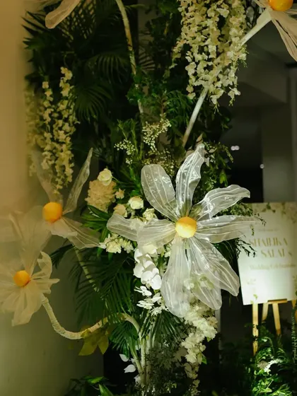 Large, artistic floral installations being set up at the entrance to welcome guests.