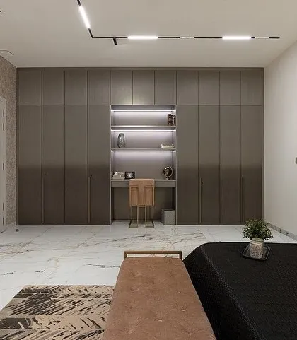 The same bedroom, showing the custom ombré grey wardrobe with an integrated study nook, designed for a modern, masculine aesthetic.