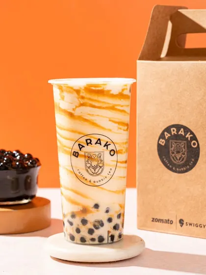 A classic brown sugar bubble tea from Barako. The shot highlights the "tiger stripes" of caramel along the side of the cup.