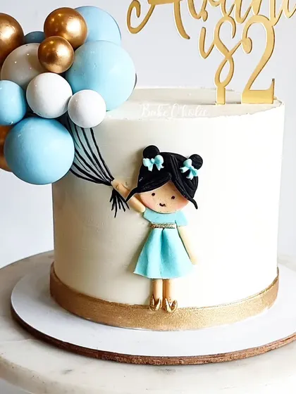 Isn't she the cutest? This cake for Avani's 2nd birthday features a sweet little girl holding a cascade of balloons, all handcrafted.