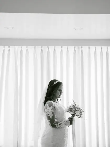 A beautiful black and white silhouette. This artistic shot highlights the bride's profile and the delicate details of her gown and veil.