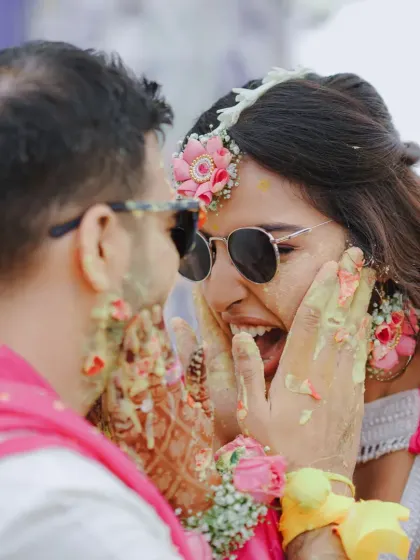 A candid moment of the couple covered in Haldi, sharing a laugh. It's my job to handle the logistics so you can focus on making these happy memories.