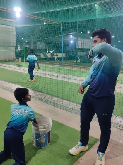 A coach works with a young bowler during a net session. We believe in nurturing talent from a young age, focusing on building a strong and repeatable action.