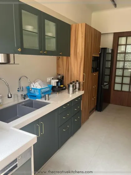 Functionality is key in this European-style kitchen. The layout provides ample counter space next to the sink and appliances, while glass-fronted upper cabinets keep the space feeling open and light.