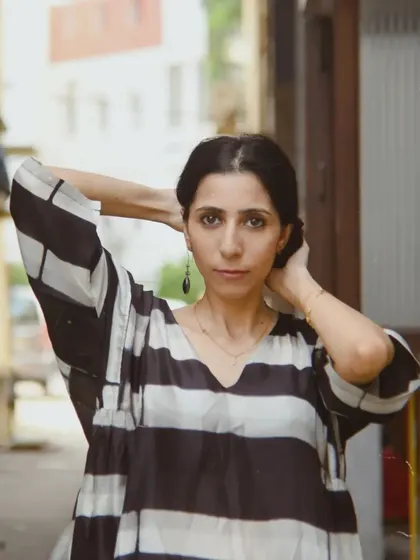 A close-up street style portrait for House of Wandering Silk, capturing a feeling of urban calm and effortless style.