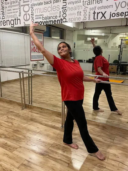 A member shows her consistency and power during a barre class, embodying the spirit of our RedMat Core Club.
