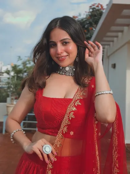 A client in a vibrant red lehenga, perfect for a festive celebration.