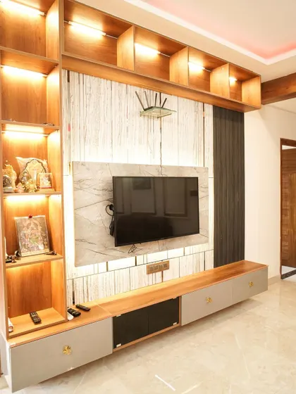 A close-up of the large, multi-functional TV unit, highlighting the ample shelving for books, decor, and electronics, all beautifully illuminated.