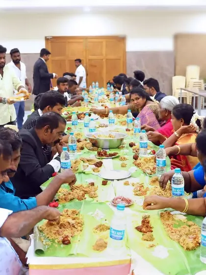 A candid shot of guests fully immersed in enjoying their meal. The empty plates and happy faces are a sign of a successful feast.
