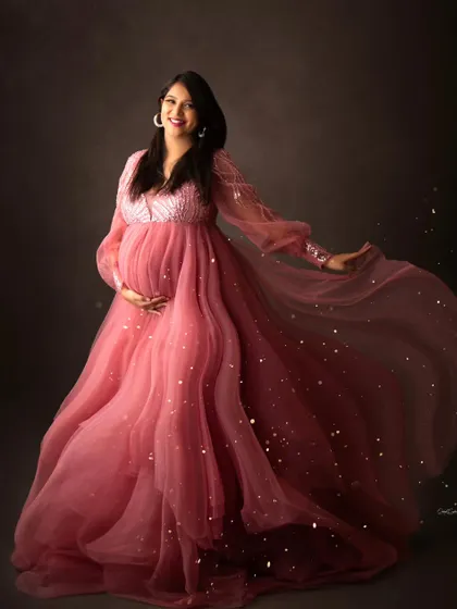 Happiness looks gorgeous on her. This mom-to-be is captured mid-twirl in a flowing pink gown, with a sprinkle of gold dust for a magical effect.