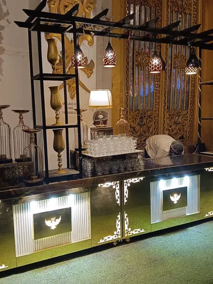 This image showcases the detailed design of our buffet counters. The setup includes integrated shelving for decor, ambient lighting, and our signature wing logo, creating a bespoke look for your event.