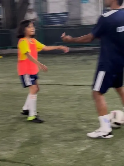 A coach gives a high-five to a young player. Positive reinforcement is a powerful tool for building confidence and encouraging effort.