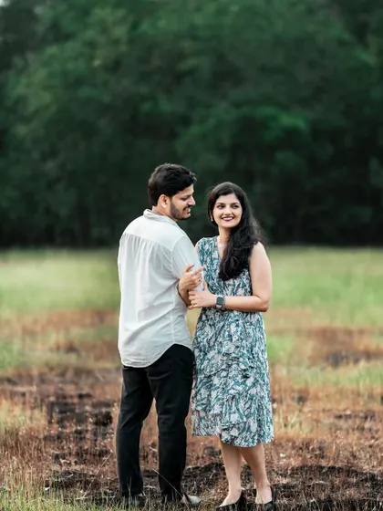 A classic couple portrait in a green field, capturing their natural smiles and easy-going chemistry.
