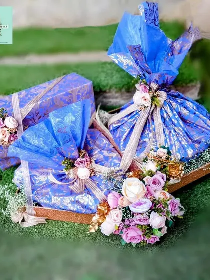 A still image of the custom floral hamper I designed for Kiara and Sidharth. The vibrant blue brocade paper and delicate flowers create a look that is both regal and romantic.