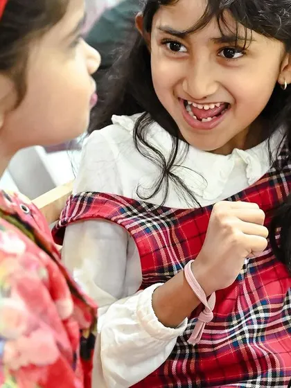 Two girls share an excited conversation during the party. These celebrations are filled with moments of friendship and joy.