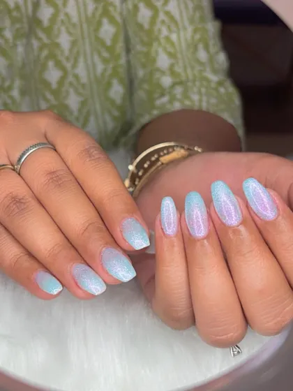 Ombré pearl glitter nails that fade from a soft blue to a shimmery white.